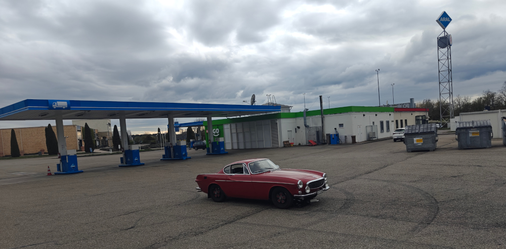 Red Volvo 1800E alone in a Autohof car park